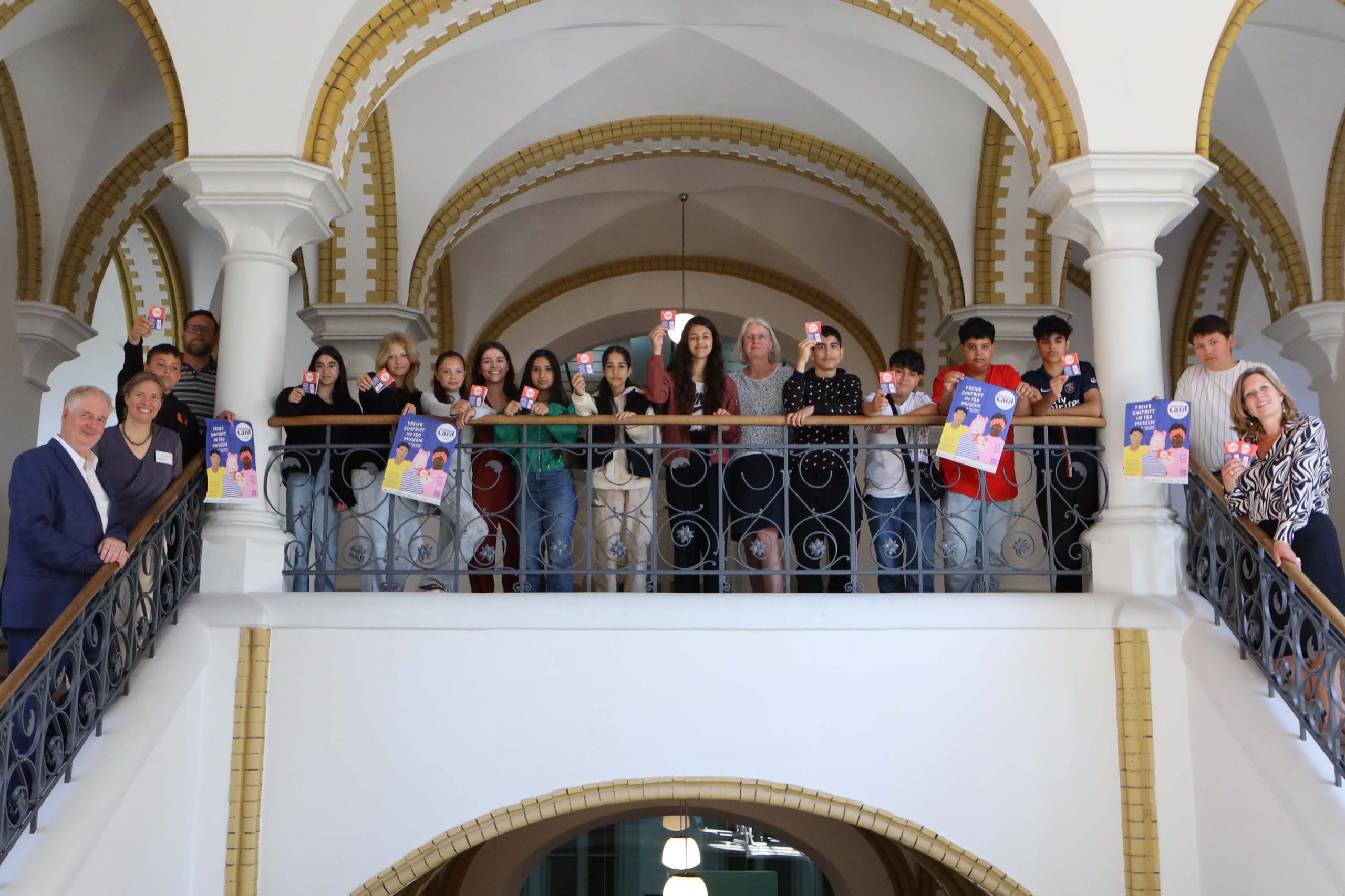 viele Menschen auf der Treppe im Gang des Museumsberg Flensburg und Poster der Museumscard.